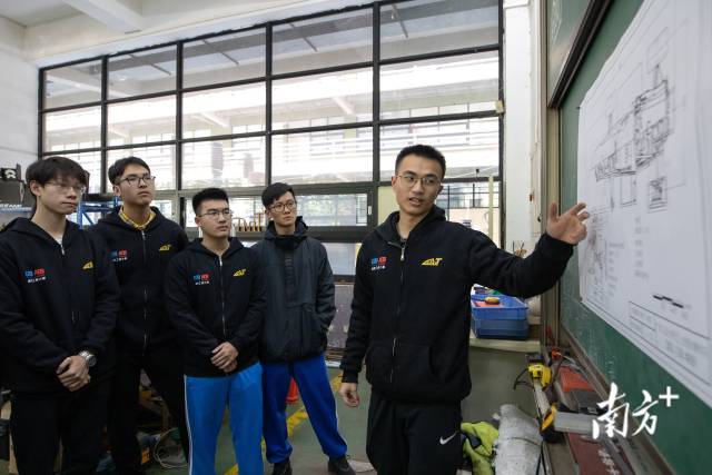 杨浩森正在向其他成员讲解车辆底盘的构造与所应用的技术。 杨浩森正在向其他成员讲解车辆底盘的构造与所应用的技术。