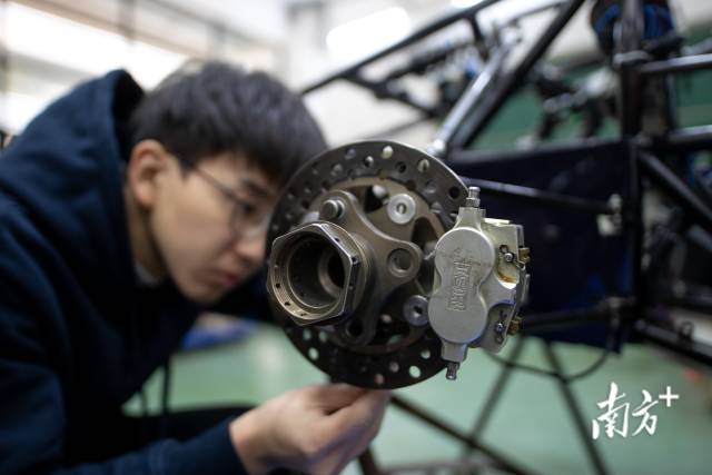 安装轮胎前,传动组成员吴敬铭正在作最后的检查。 安装轮胎前,传动组成员吴敬铭正在作最后的检查。